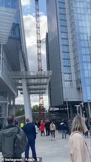 Onlookers watch as the man scaled the crane next to the shard and stood on the crane fitting