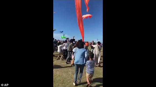 Crowds scrambled to catch the girl after a sudden gust caught her up in a large orange kite at a festival in Taiwan on Sunday