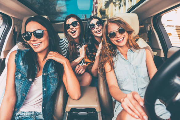 Four beautiful young cheerful women looking at camera with smile while sitting in car - What type of Woman does the Scorpio Man Prefer Physically