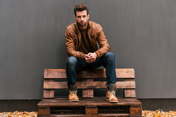 Handsome young Scorpio man sitting on the wooden pallet - Why Scorpio Men Are Not Forthcoming With Their Feelings